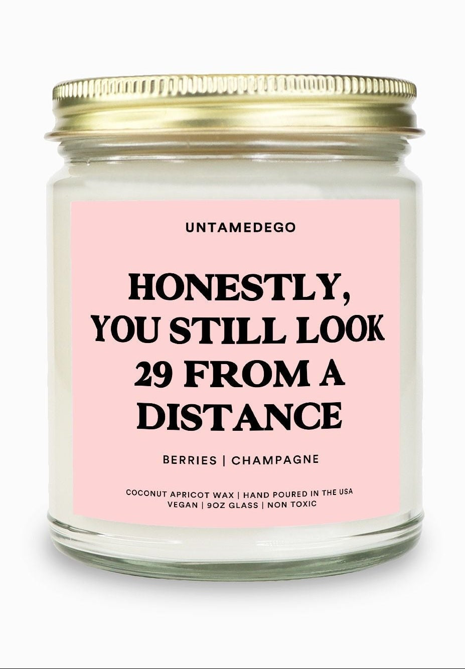 Candle with a pink label and gold lid on a white background