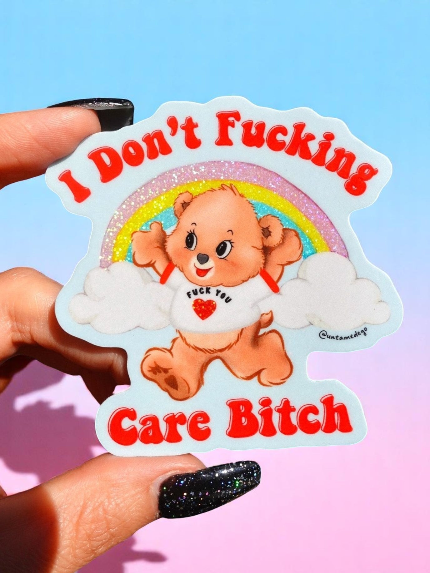 Sticker with a bear character and text held by a hand against a colorful background