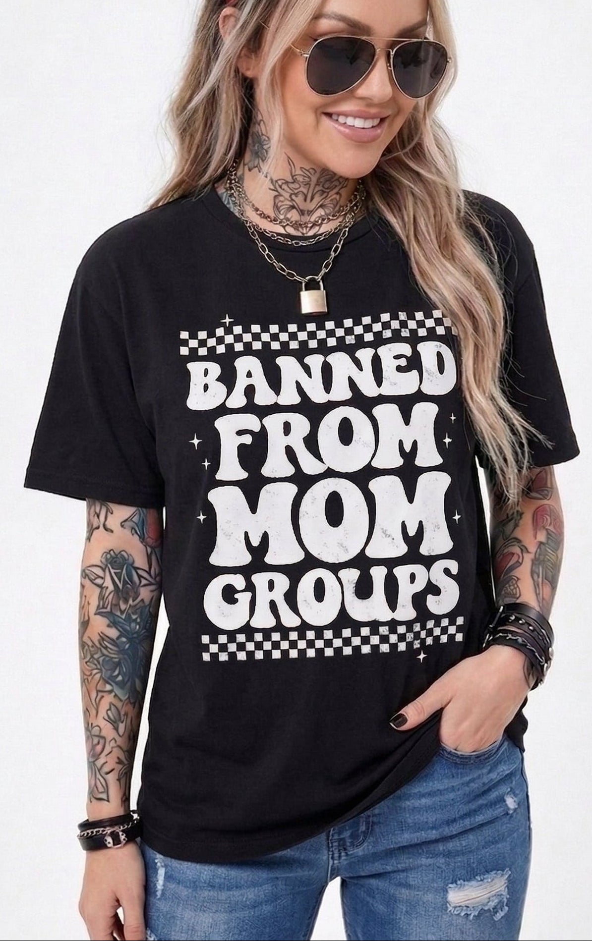 Woman wearing a black t-shirt with 'Banned from Mom Groups' text on a white background