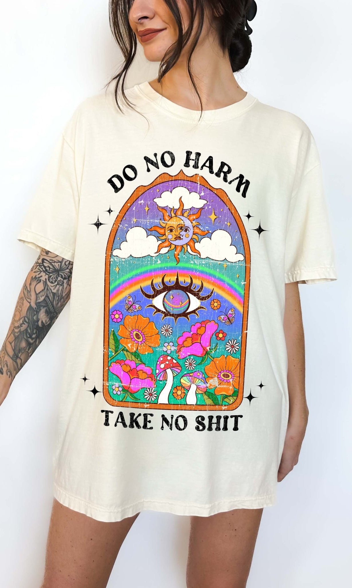 Spiritual graphic t-shirt with sun, rainbow, flowers, and text saying do no harm take no shit