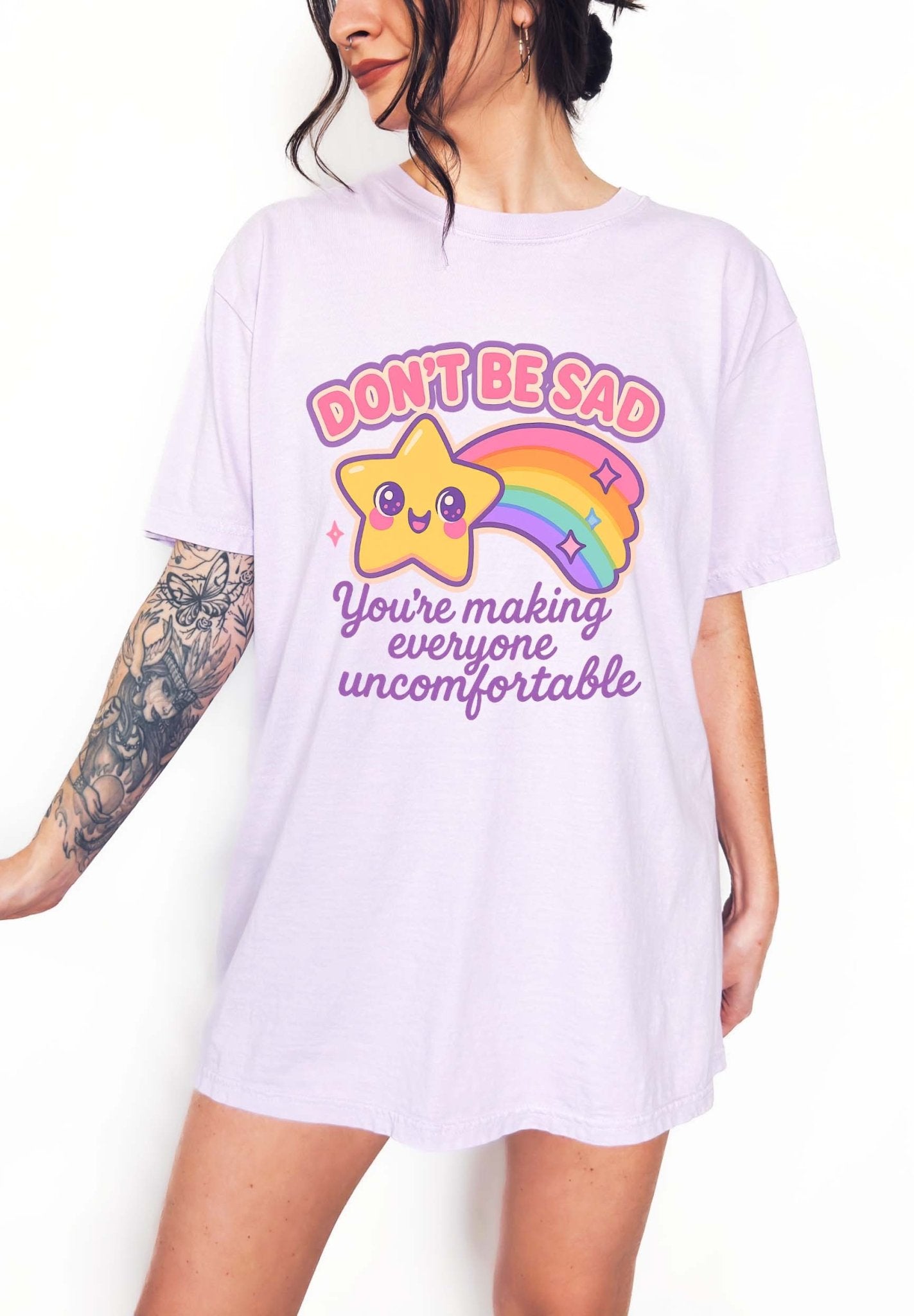 Funny graphic t-shirt with cute star and rainbow design and text saying don’t be sad you’re making everyone uncomfortable