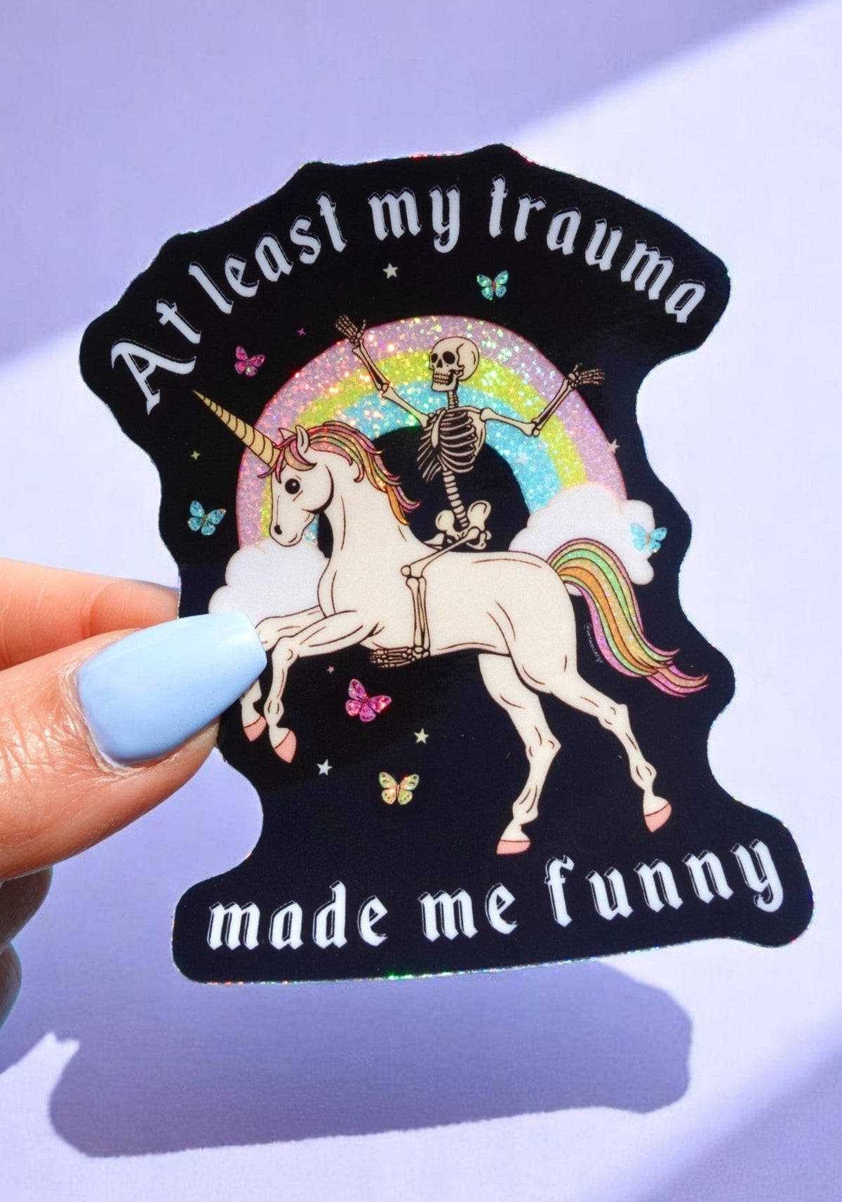 t-least-my-trauma-made-me-funny-unicorn-skeleton-holographic-sticker.