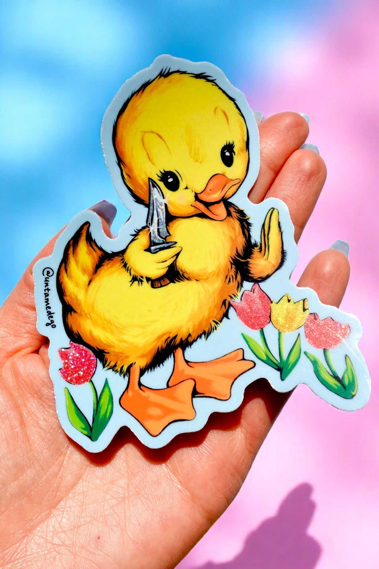 Funny vinyl sticker of a cute yellow duck holding a knife, standing among glitter tulips. Dark humor waterproof sticker with pastel aesthetic.