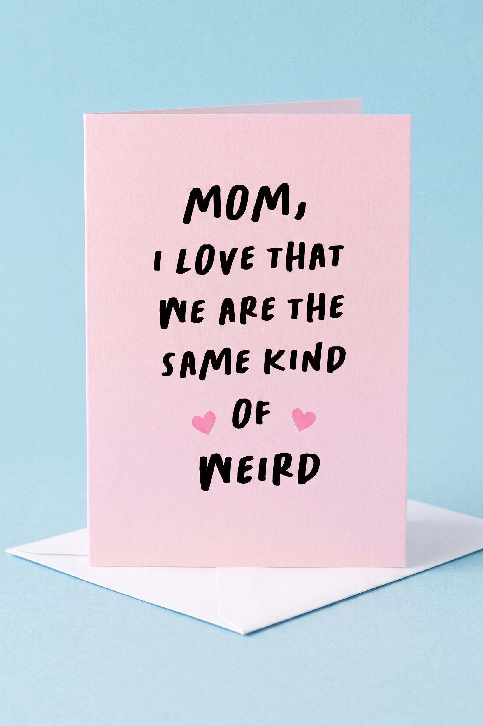 Greeting card with text 'Mom, I love that we are the same kind of weird' on a pink background