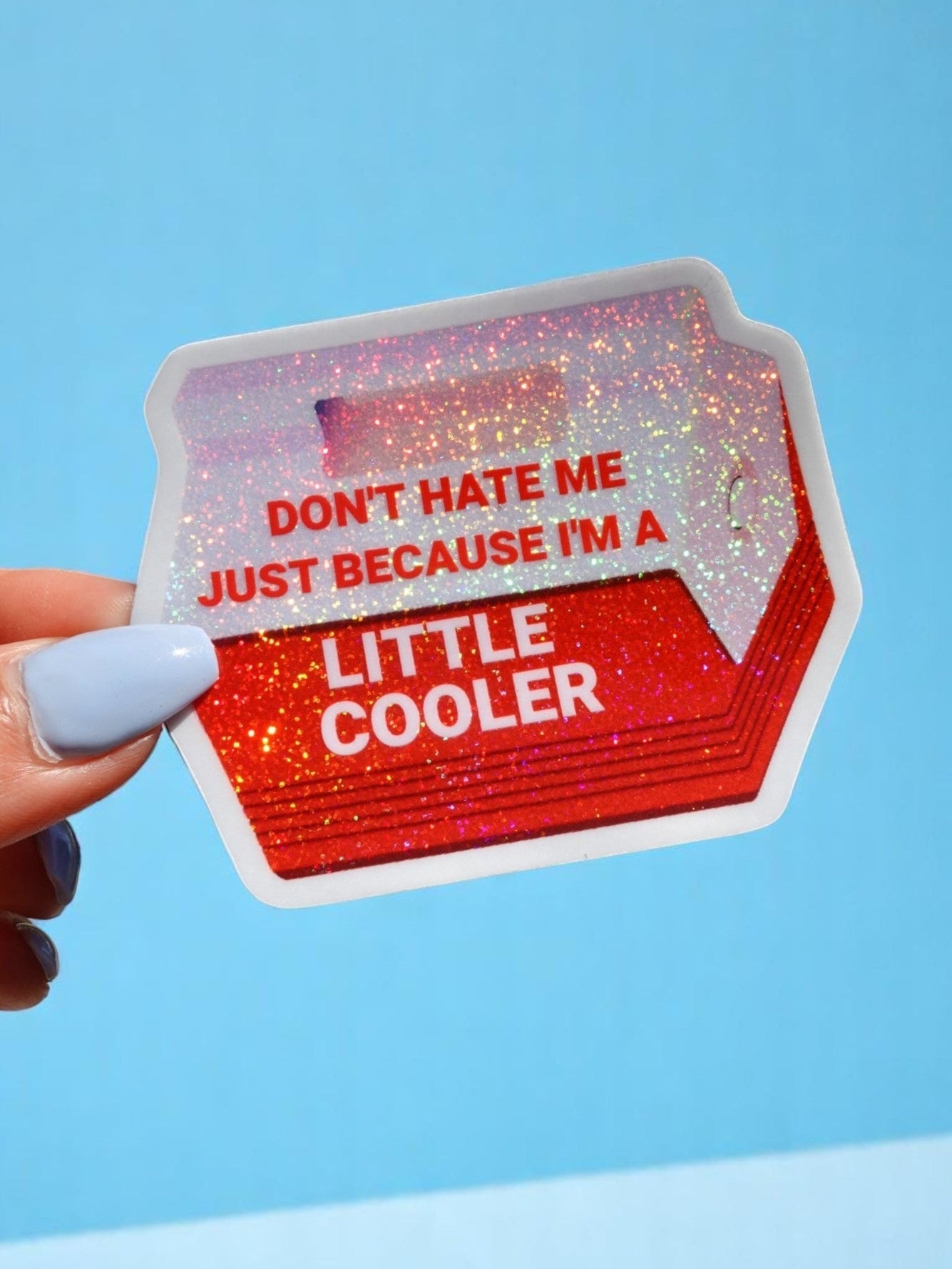 Red holographic cooler-shaped vinyl sticker held in hand against neutral background. Text reads Don't Hate Me Just Because I'm a Little Cooler.