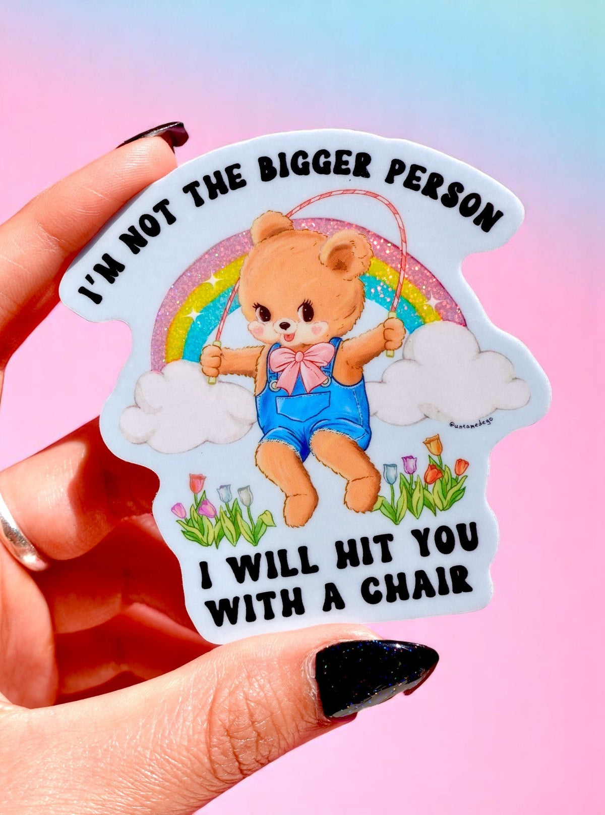 Die-cut holographic glitter vinyl sticker of a teddy bear with rainbow and tulips. Text reads I'm Not The Bigger Person I Will Hit You With A Chair.