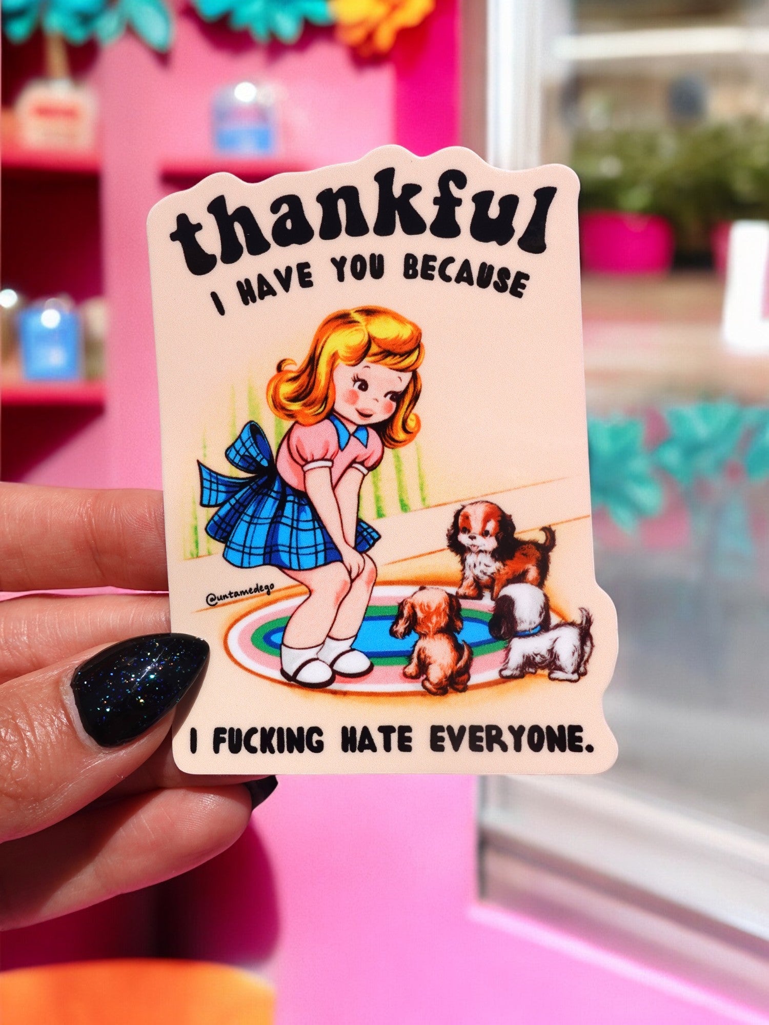 Die-cut glossy vinyl sticker featuring a retro-style illustration of a blonde girl in a blue dress sitting on a rug with two puppies. Text reads: Thankful I Have You Because I Fucking Hate Everyone.