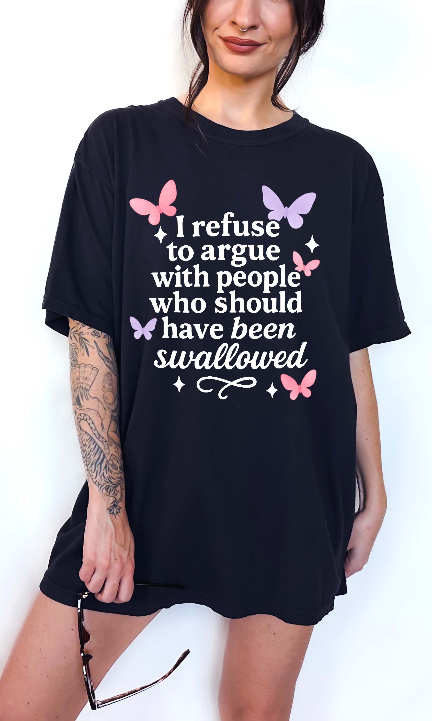 Person wearing a black t-shirt with text and butterfly graphics on a white background