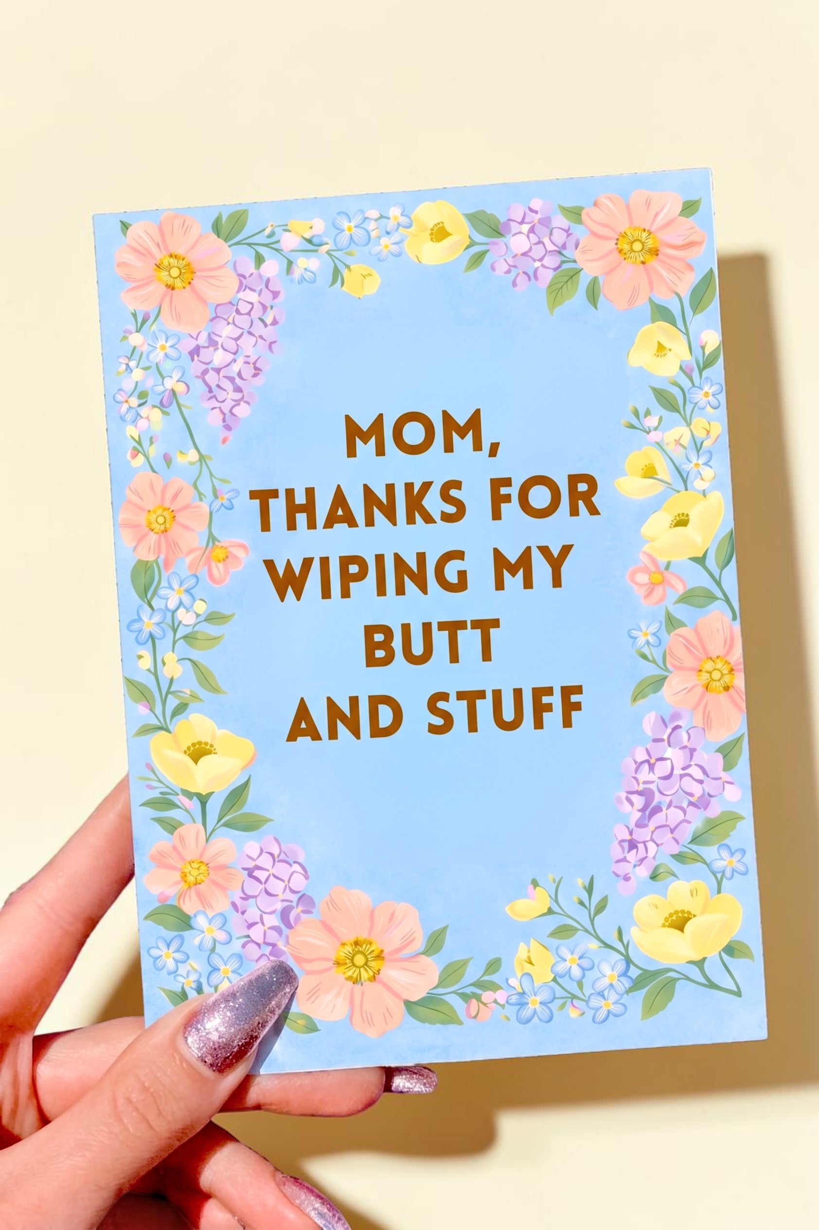 Floral Mother’s Day card with blue background and text reading “Mom thanks for wiping my butt and stuff”