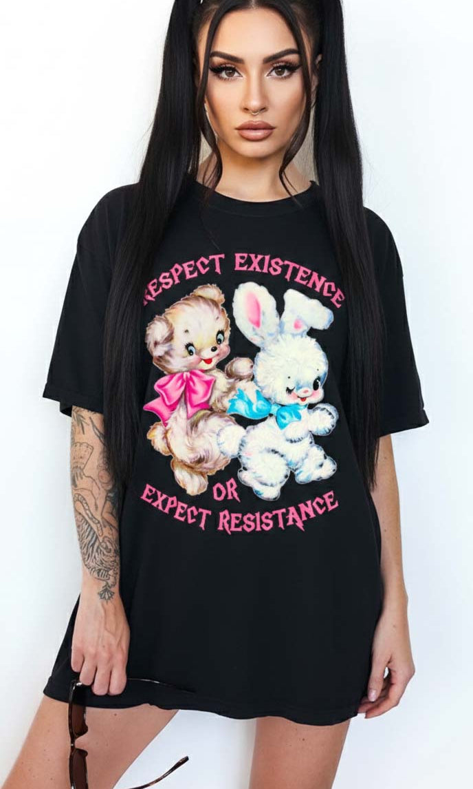 Person wearing a black graphic t-shirt featuring two illustrated characters and the text Respect Existence Or Expect Resistance, photographed against a light background