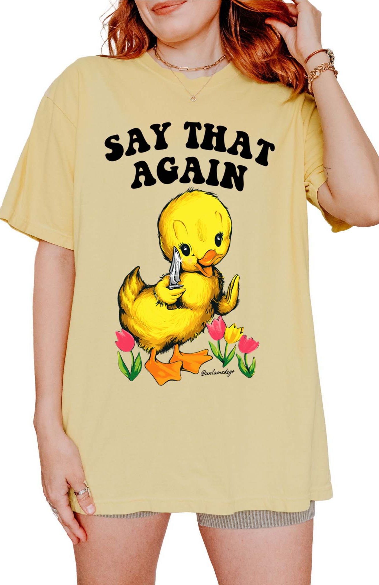 Funny graphic t-shirt with cute duck holding knife and text saying say that again