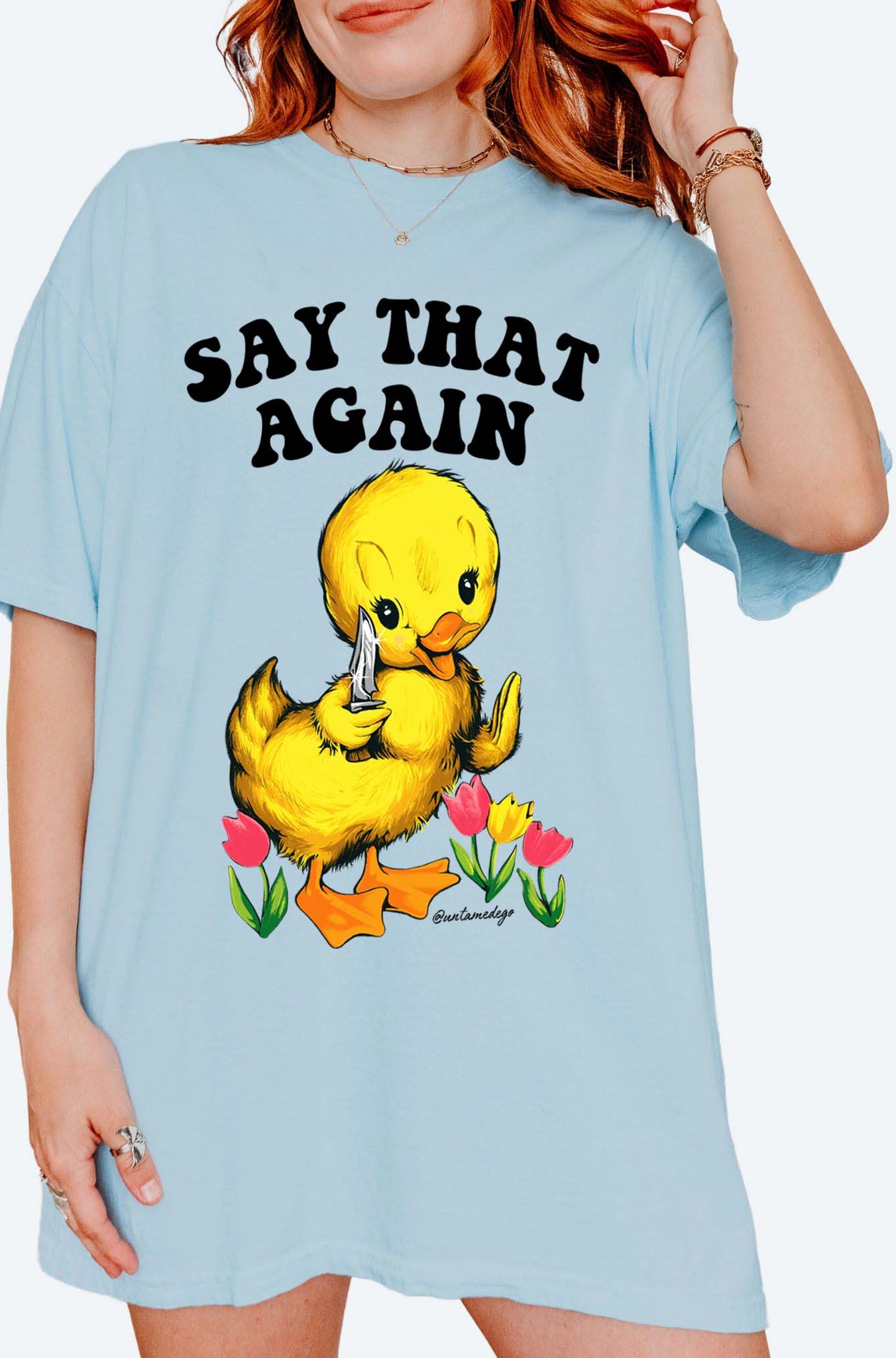 Funny graphic t-shirt with cute duck holding knife and text saying say that again