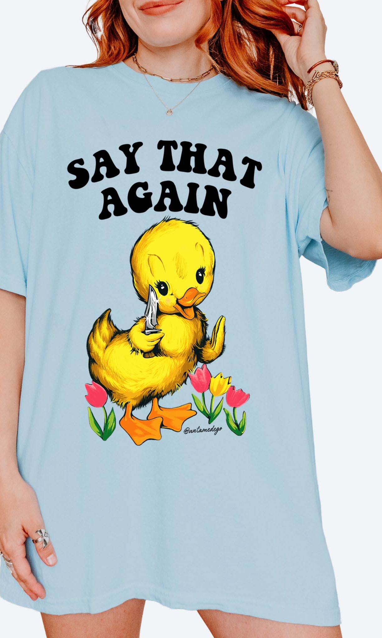 Funny graphic t-shirt with cute duck holding knife and text saying say that again