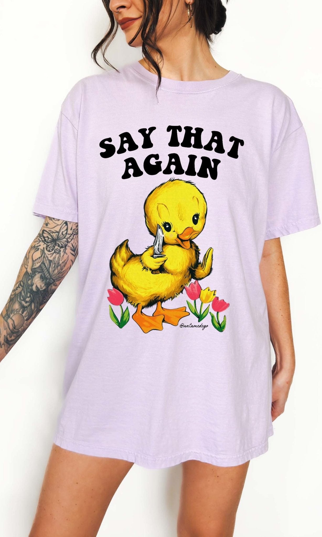 Funny graphic t-shirt with cute duck holding knife and text saying say that again