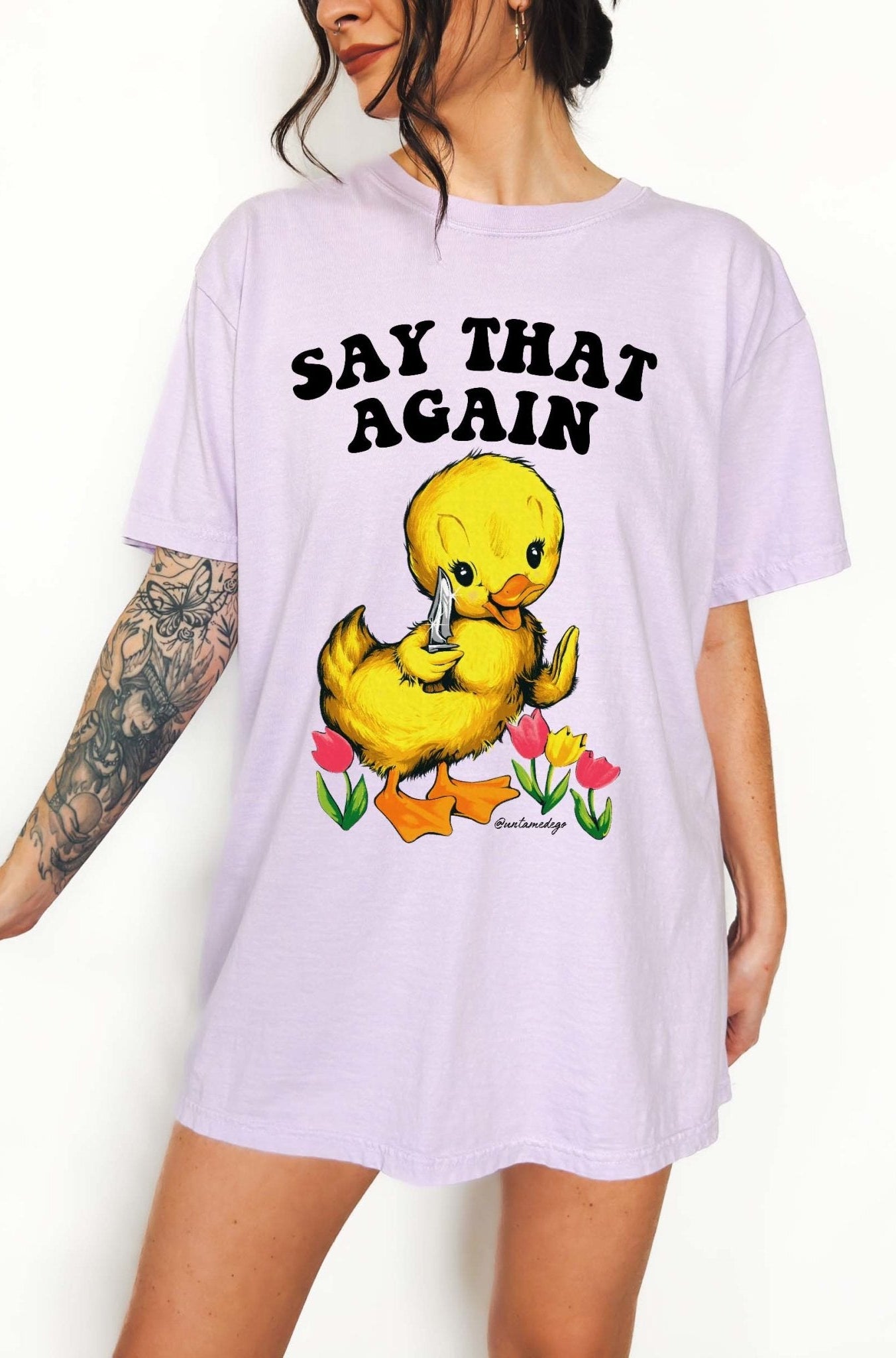 Funny graphic t-shirt with cute duck holding knife and text saying say that again