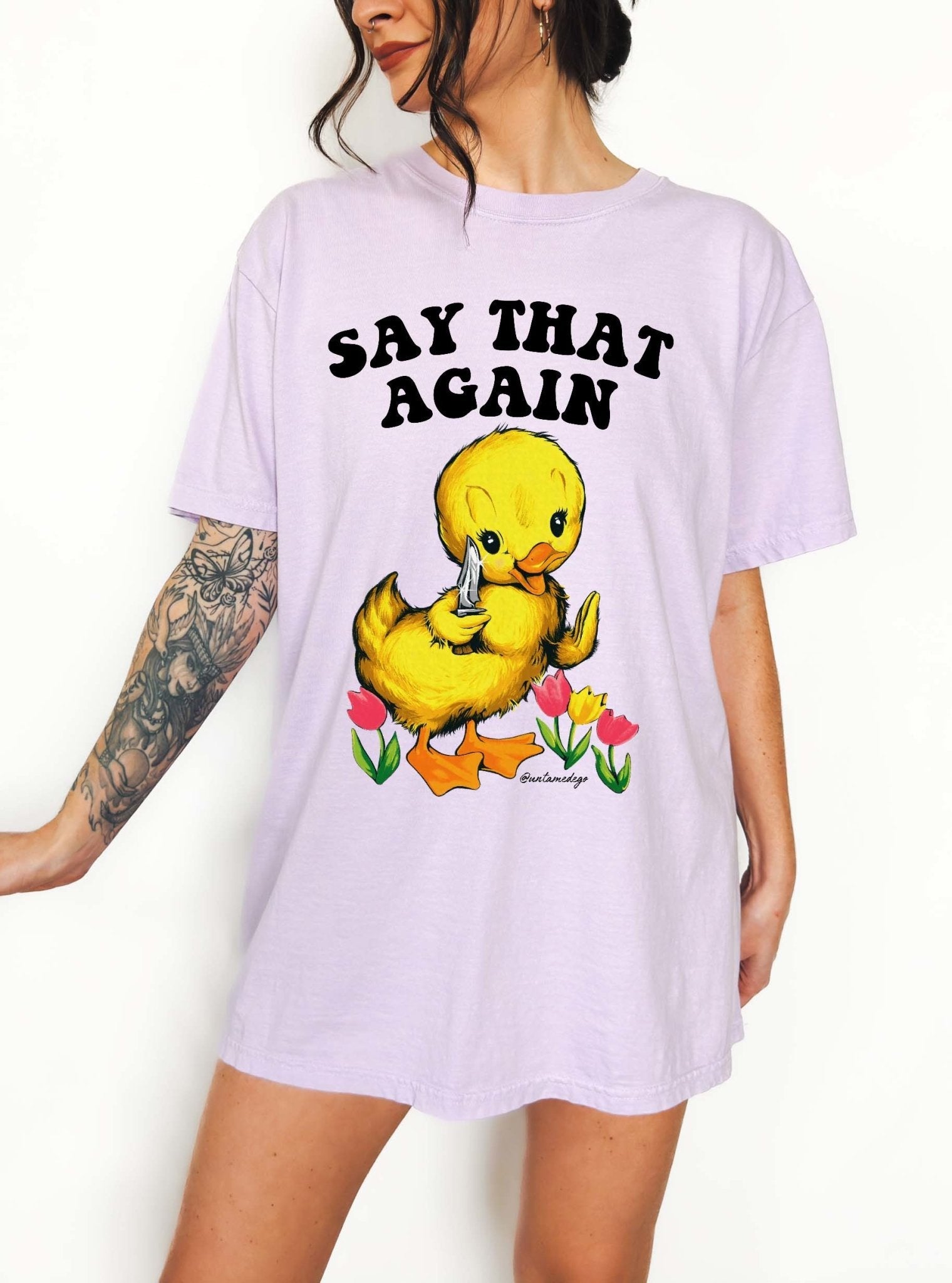 Funny graphic t-shirt with cute duck holding knife and text saying say that again