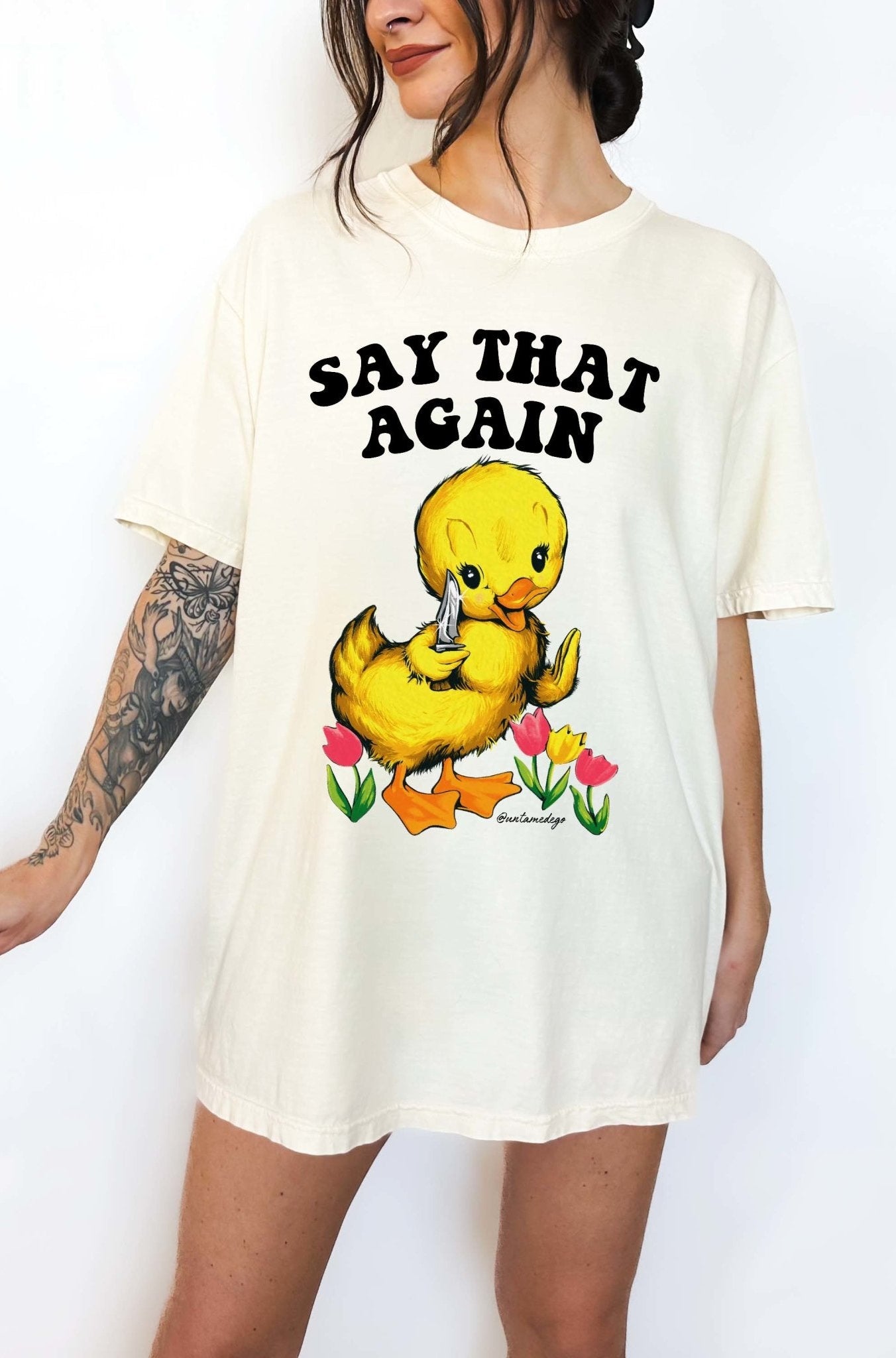 Funny graphic t-shirt with cute duck holding knife and text saying say that again