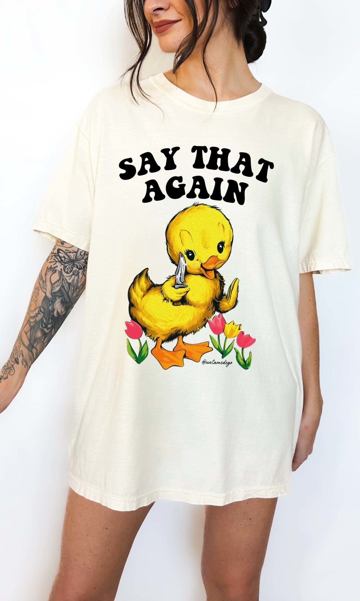 Funny graphic t-shirt with cute duck holding knife and text saying say that again