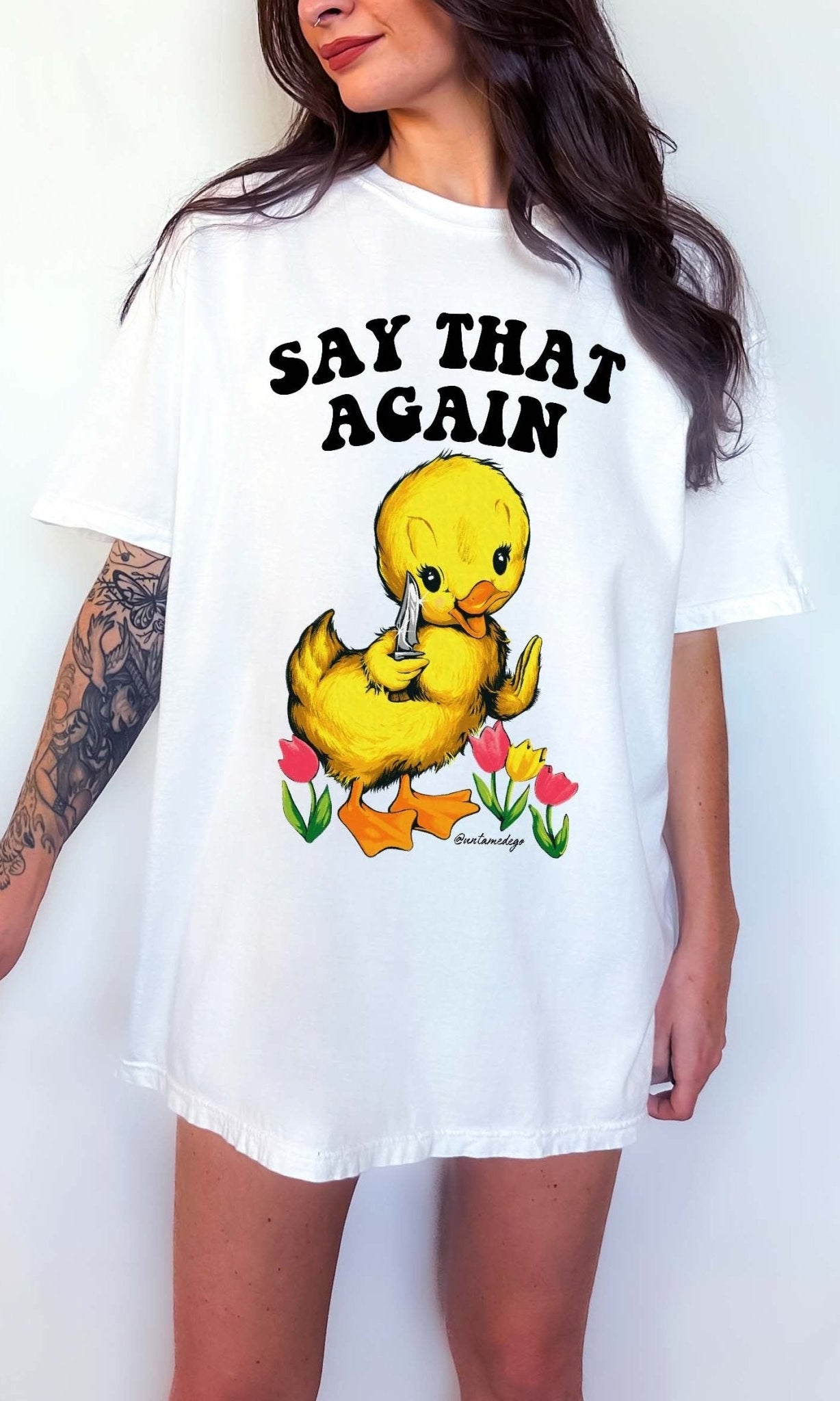 Funny graphic t-shirt with cute duck holding knife and text saying say that again