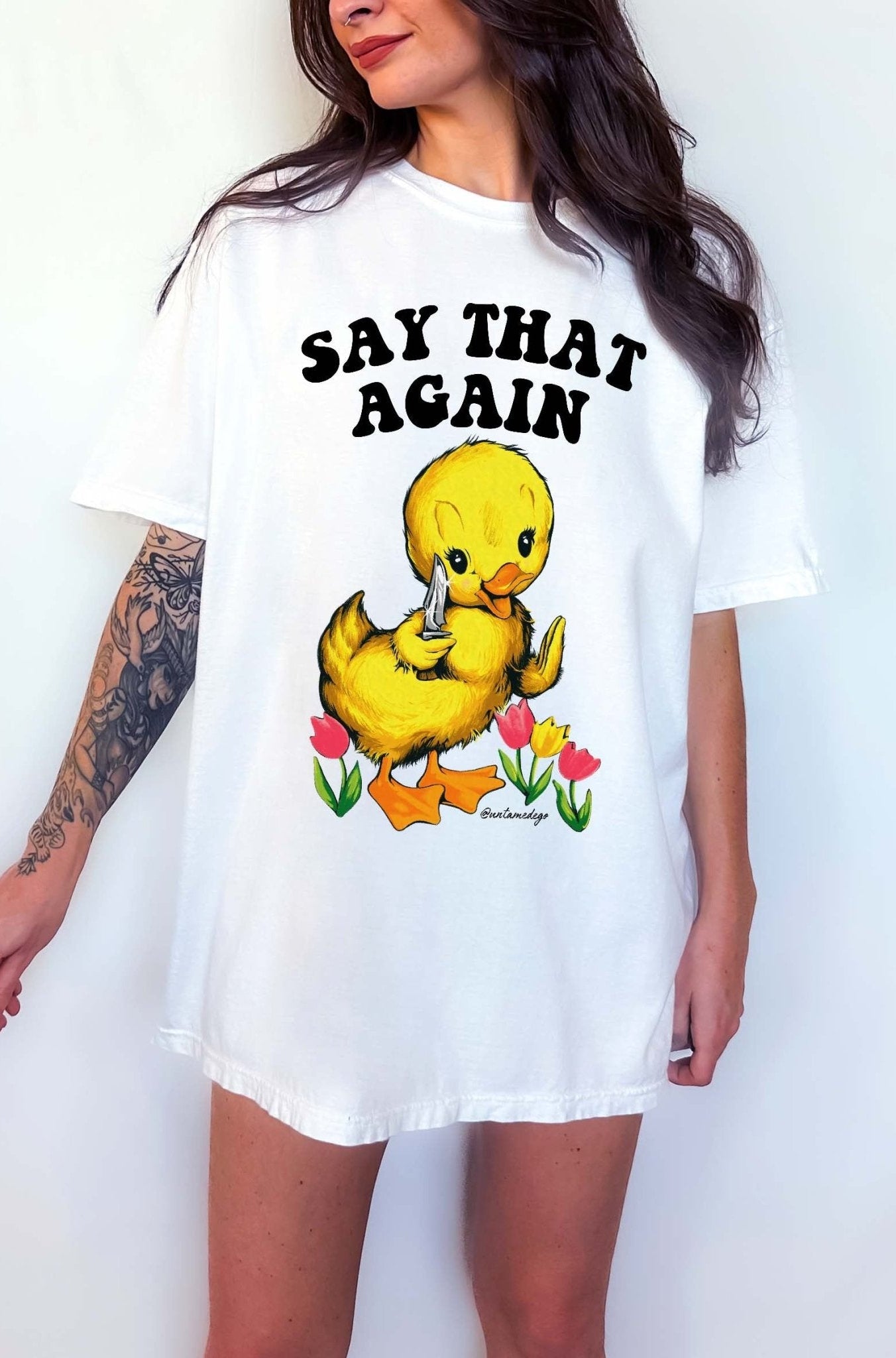 Funny graphic t-shirt with cute duck holding knife and text saying say that again