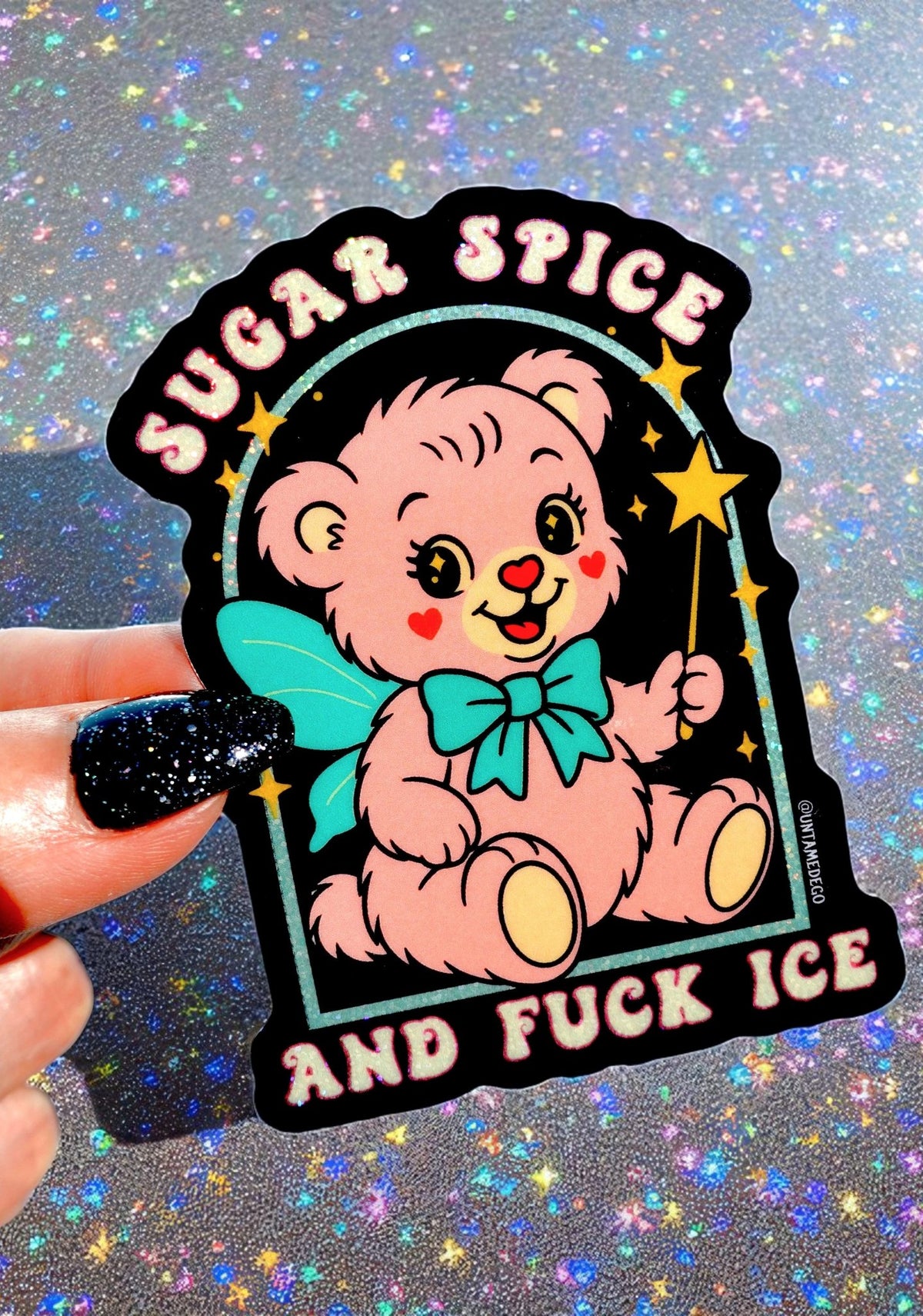 Die-cut holographic glitter vinyl sticker on a black background featuring a retro kawaii bear with a teal bow and stars. Arched text at top reads Sugar Spice and text at bottom reads And Fuck ICE.