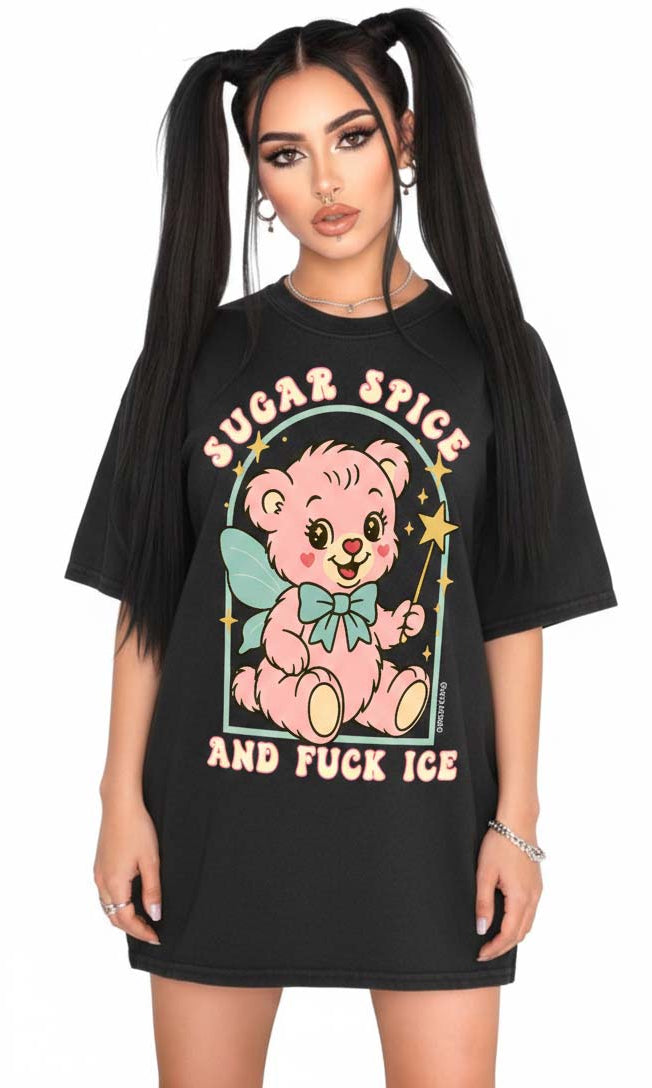 Person wearing a black graphic t-shirt featuring a pastel illustrated bear holding a wand and text that reads Sugar Spice and F star ICE, photographed against a white background