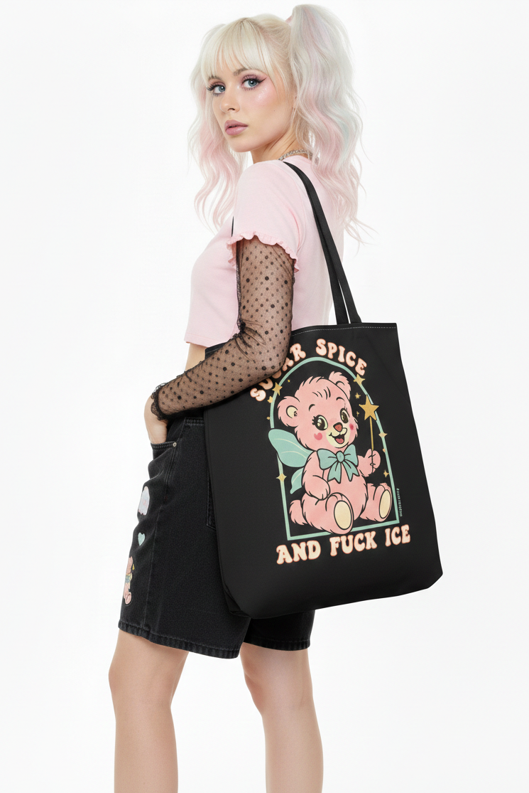 Person holding a black tote bag with a graphic design and text.