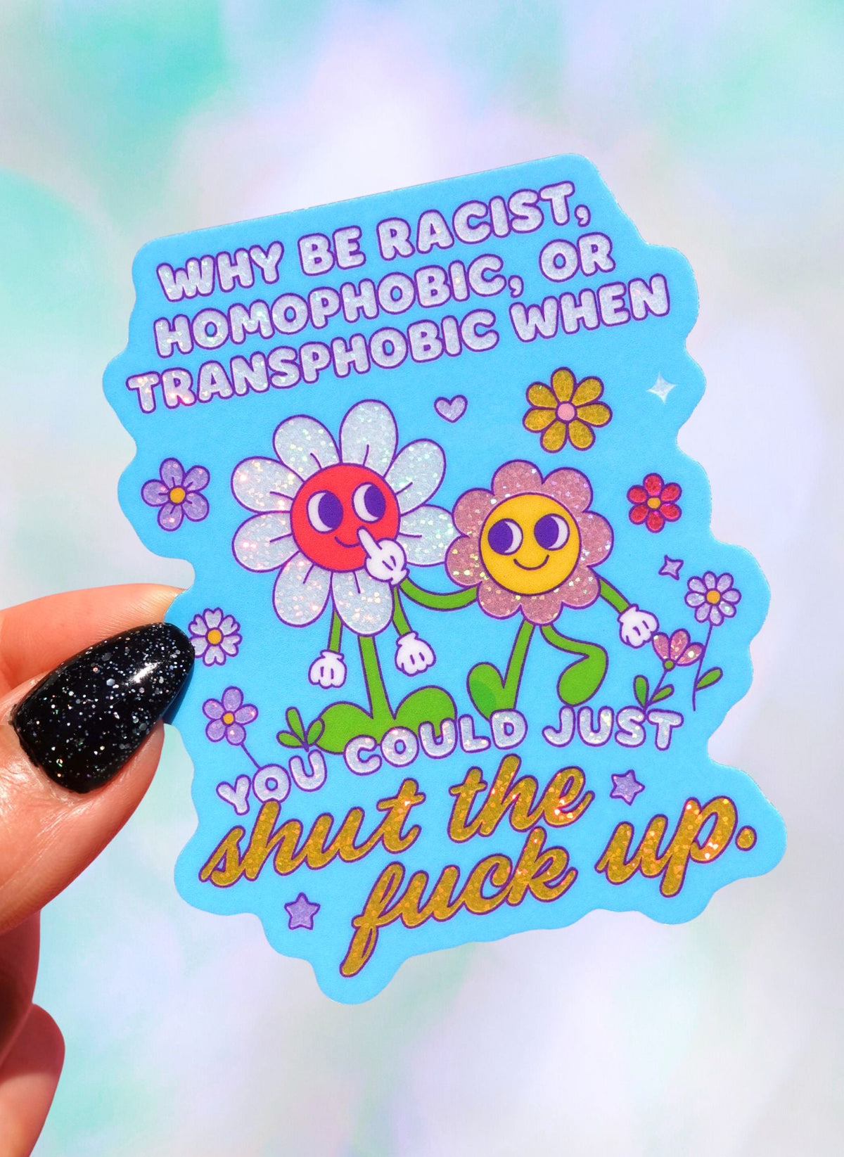 Die-cut holographic vinyl sticker on a light blue background featuring two retro smiley-face flowers with colorful floral accents. Text reads Why Be Racist Homophobic Or Transphobic When You Could Just Shut The Fuck Up.