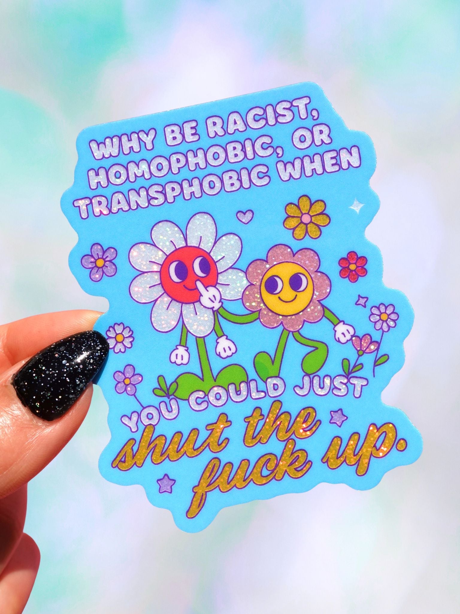 Die-cut holographic vinyl sticker on a light blue background featuring two retro smiley-face flowers with colorful floral accents. Text reads Why Be Racist Homophobic Or Transphobic When You Could Just Shut The Fuck Up.