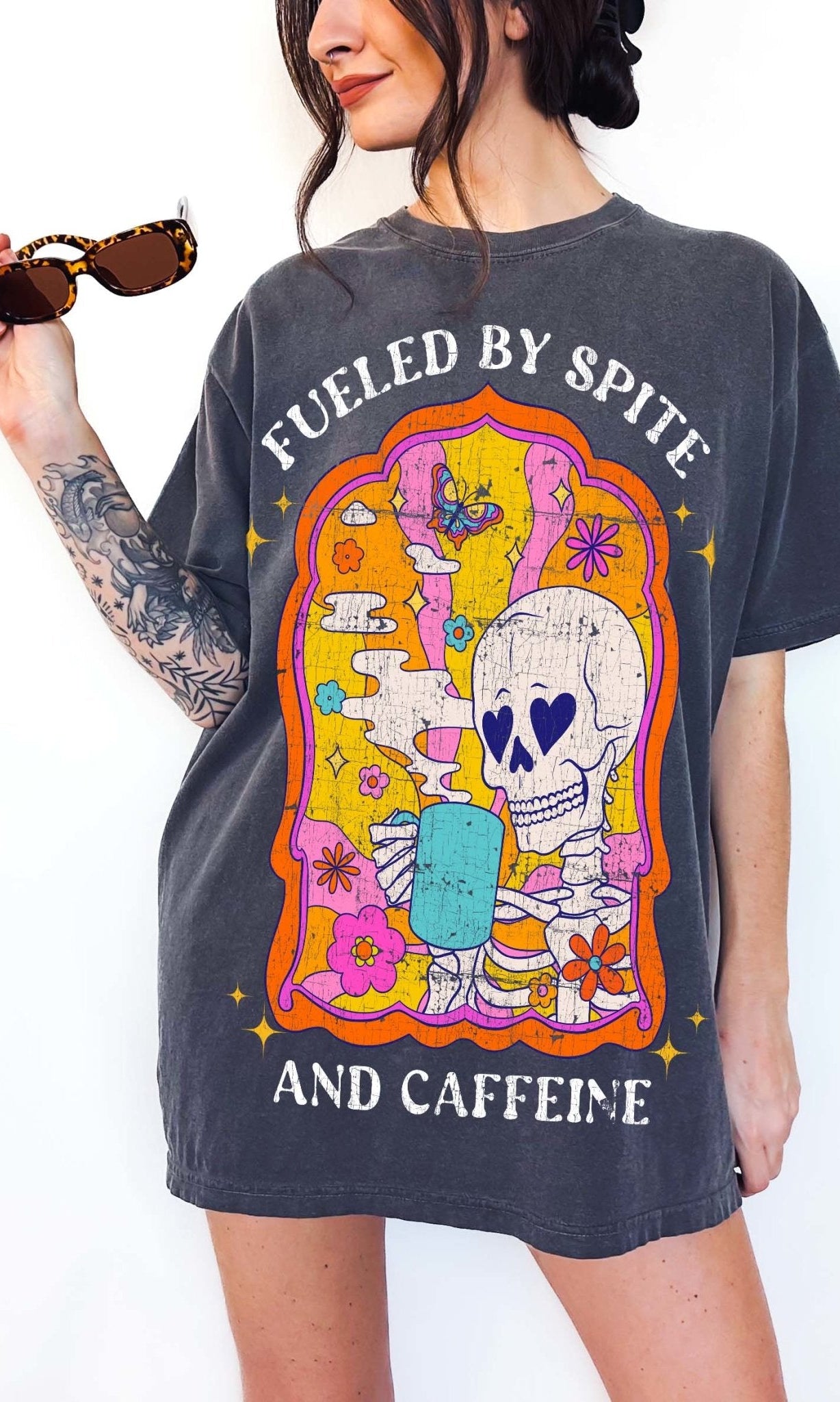 Funny coffee t-shirt with skeleton drinking coffee and text saying fueled by spite and caffeine