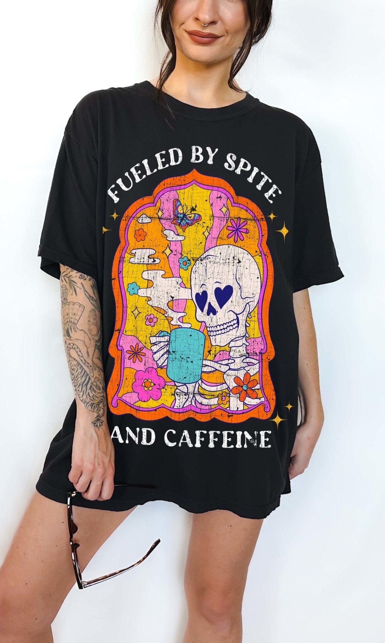 Funny coffee t-shirt with skeleton drinking coffee and text saying fueled by spite and caffeine