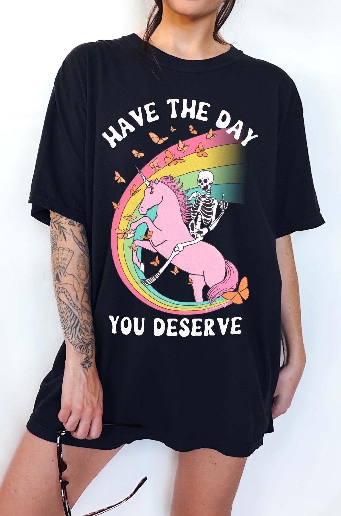 Funny sarcastic t-shirt with unicorn and skeleton design and text saying have the day you deserve