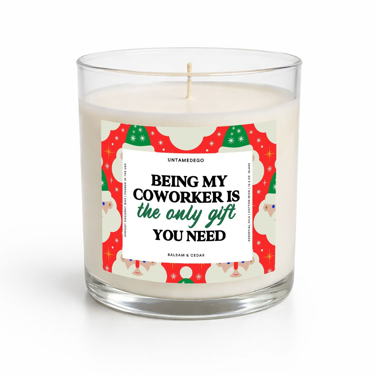 A clear glass jar candle with white wax and a humorous holiday-themed paper label that reads 'BEING MY COWORKER IS the only gift YOU NEED' in black and green text, set against a clean white background.