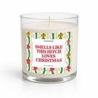 A clear glass jar candle with white wax and a humorous Christmas-themed label that reads 'SMELLS LIKE THIS BITCH LOVES CHRISTMAS' in red text, surrounded by festive green, red, and yellow holiday illustrations. The brand name 'UNFAMILIAROO' is visible at the top of the label.