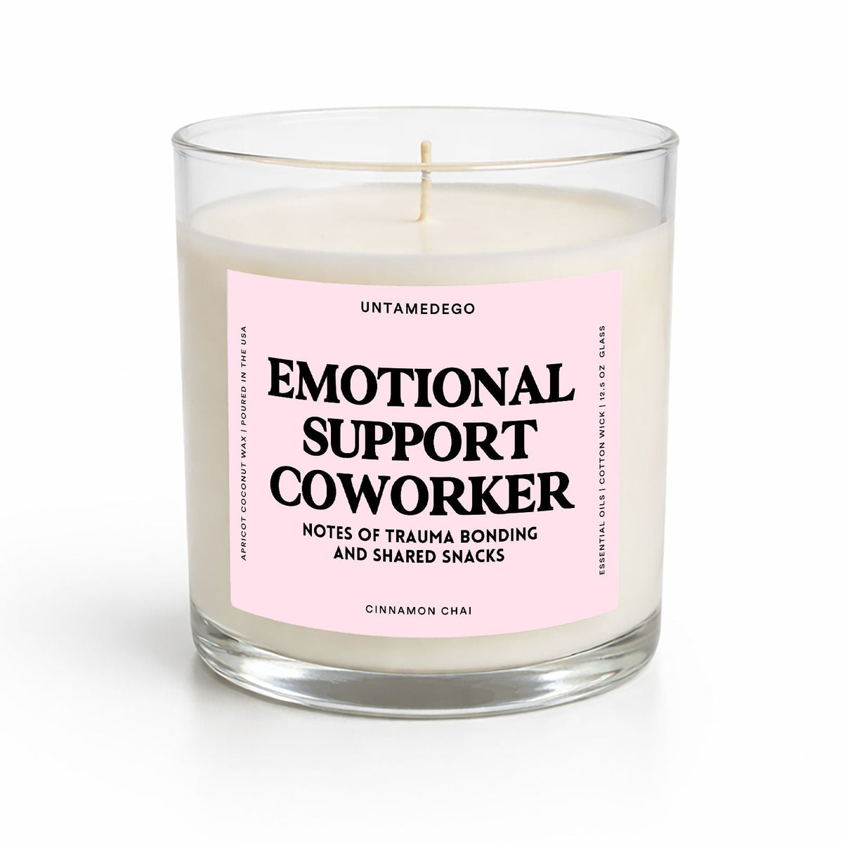 A glass jar candle with cream-colored wax and a light pink label that reads 'EMOTIONAL SUPPORT COWORKER' in bold black text. The candle is photographed on a clean white background with a soft shadow underneath.