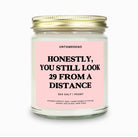 Candle with pink label and gold lid on a white background