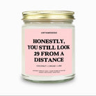 Candle with pink label and gold lid on a white background