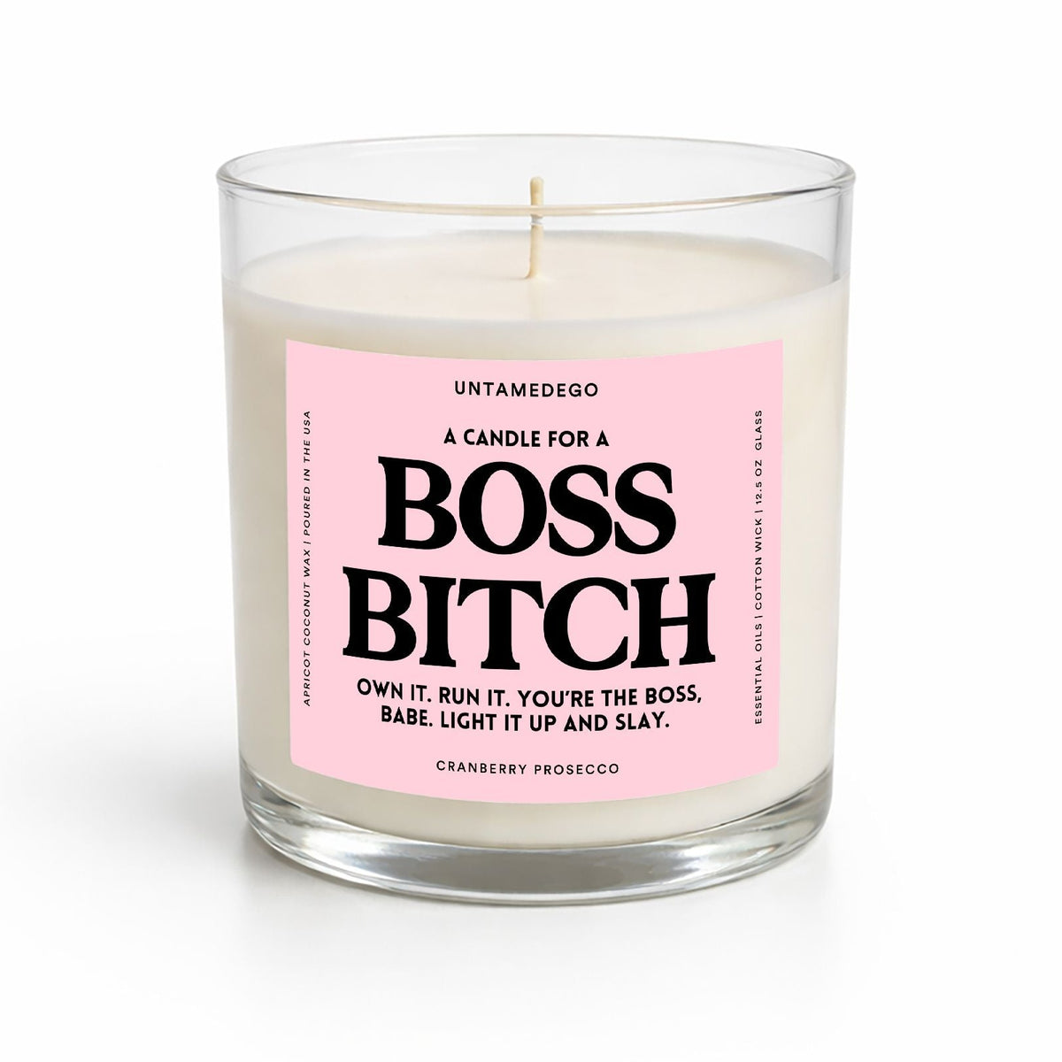 A sea salt and orchid scented candle in a clear glass jar with a pink label that reads 'UNTAMEDOGO A CANDLE FOR A BOSS BITCH' on a white background.