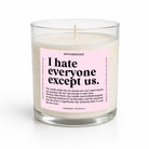 A clear glass jar candle with white wax and a pink label reading 'I hate everyone except us.' by UNTAMEDEGO, shown on a clean white background.