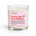 A handcrafted coconut soy candle in a clear glass jar with a pink and red label that reads 'You Put The Ho In Holidays' and 'Cranberry Prosecco'.