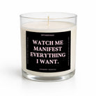 A clear glass jar candle with cream-colored wax and a black label featuring the text 'WATCH ME MANIFEST EVERYTHING I WANT.' in white and pink lettering.