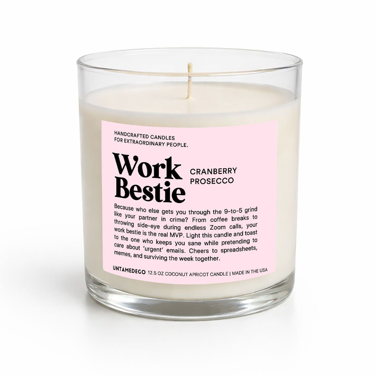 A handcrafted soy candle in a clear glass jar with a white wick and a light pink label reading 'Work Bestie' and 'Cranberry Prosecco' by Unlandego, shown on a white background.