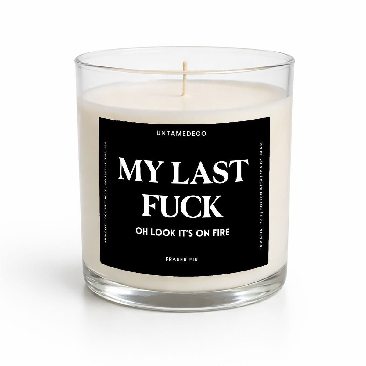 A single-wick soy candle in a clear glass jar with a black label that reads 'MY LAST FUCK OH LOOK IT'S ON FIRE' and 'VANILLA BEAN' at the bottom. The candle is photographed on a clean white background.