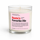 A handcrafted soy candle in a clear glass jar with a pink and white label that reads 'Santa's Favorite Ho' by Fraser Fir. The candle is photographed on a clean white background with a soft shadow.