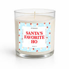 A clear glass jar candle with white wax and a festive label that reads 'SANTA'S FAVORITE HO' in red text on a light blue background with Santa illustrations. The brand name 'UNTRAMEDGO' is visible at the top of the label.