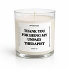 Candle in a glass jar with a label reading 'Thank you for being my unpaid therapist' on a white background.