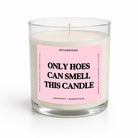 A clear glass jar candle with white wax and a pink label that reads 'ONLY HOES CAN SMELL THIS CANDLE' in bold black text. The brand name 'UNTAMEDEGO' is visible at the top of the label.