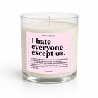 A clear glass jar candle with white wax and a pink label reading 'I hate everyone except us.' by UNTAMEDEGO, shown on a clean white background.