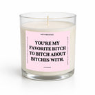 A clear glass jar candle with white wax and a pink label featuring bold black text that reads, 'YOU'RE MY FAVORITE BITCH TO BITCH ABOUT BITCHES WITH.' The brand name UNTAMEDEGO is visible at the top of the label, with 'LAVENDER' at the bottom.
