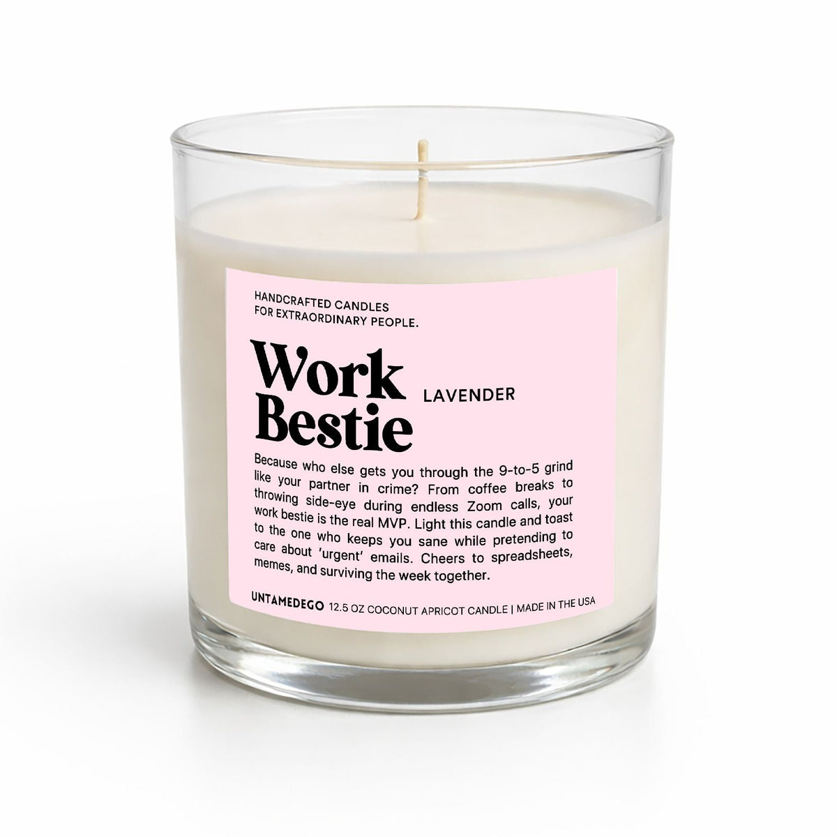 A handcrafted candle in a clear glass jar with a pink label reading 'Work Bestie Lavender' on a white background.